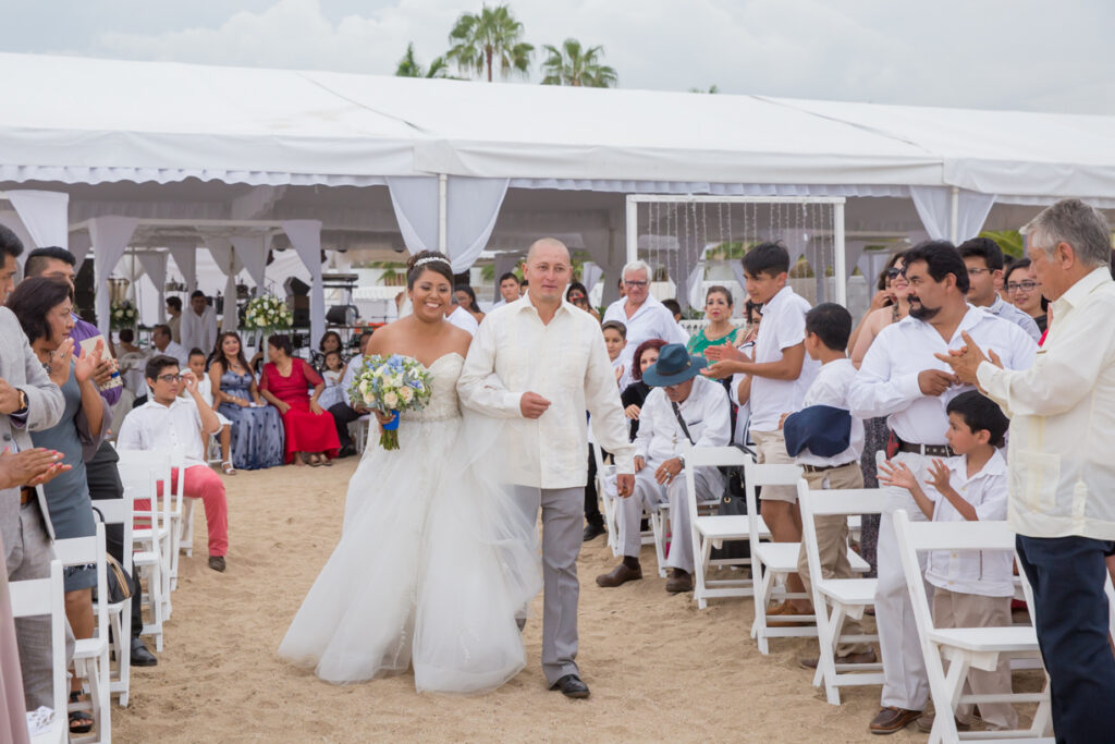 Primera Boda en Chahue Corner pareja caminando hacia el altar en su boda en la playa de Sea Soul, Huatulco
